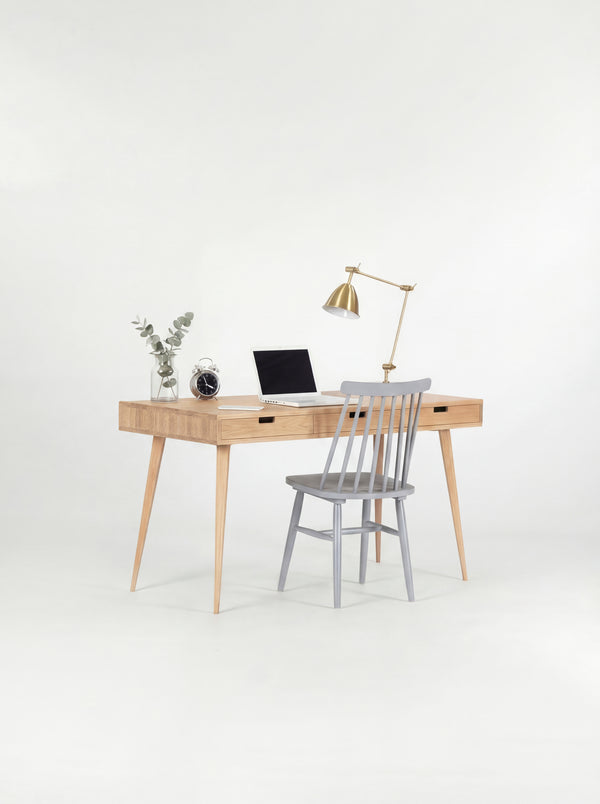 HEIM 140 desk in solid oak with a grey spindle chair pulled up, a laptop and eucalyptus on top