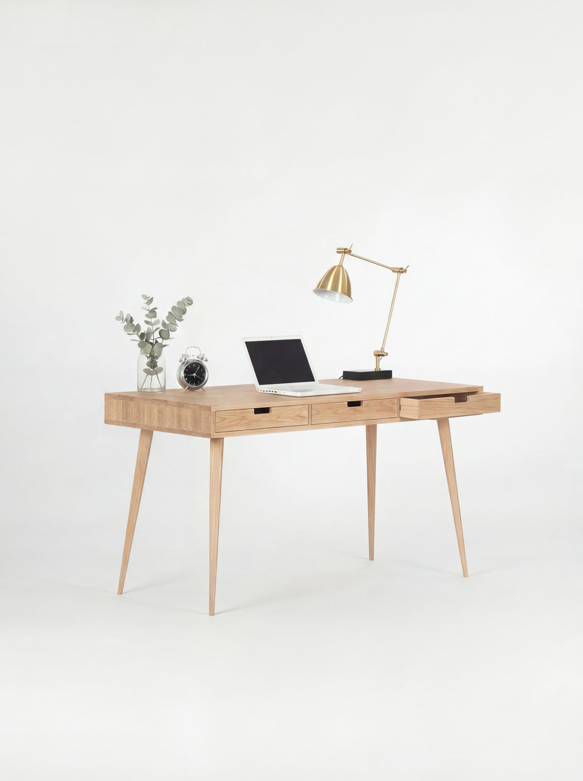 HEIM 140 computer desk with drawers in solid oak, seen at an angle with the right drawer open and a laptop on top