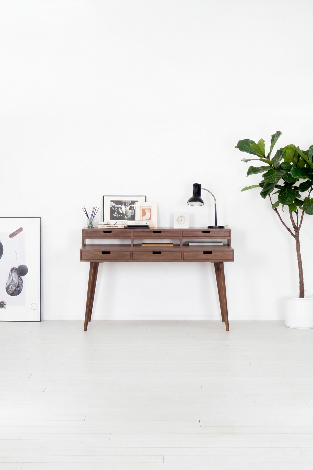 HEIM 140 computer desk with hutch in solid walnut, front view in a bright room with a plant and poster