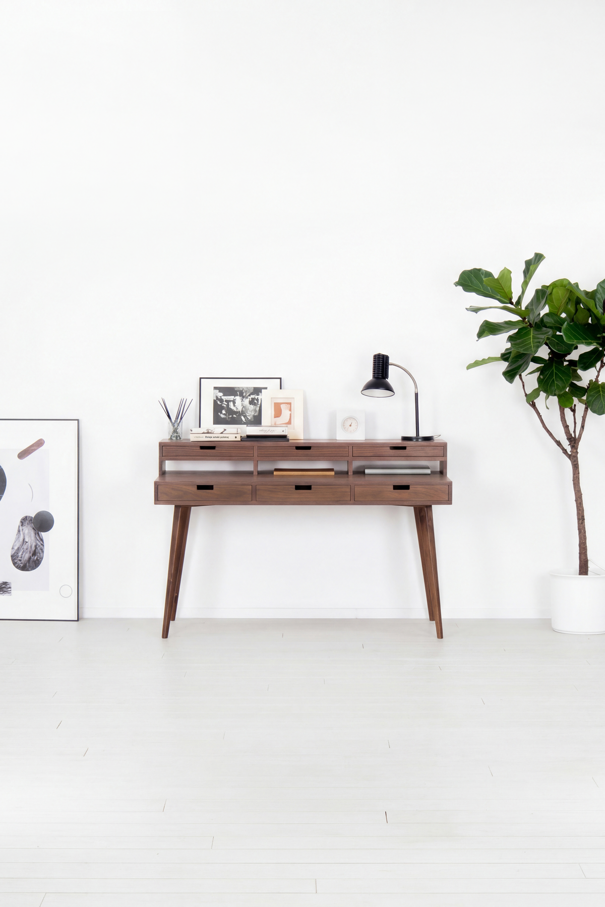 HEIM 140 computer desk with hutch in solid walnut, front view in a bright room with a plant and poster