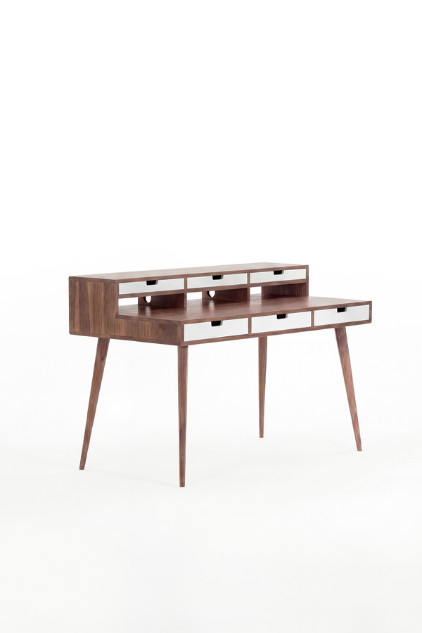 HEIM 140 desk in solid walnut, three-quarter view with six white drawer fronts and an empty top