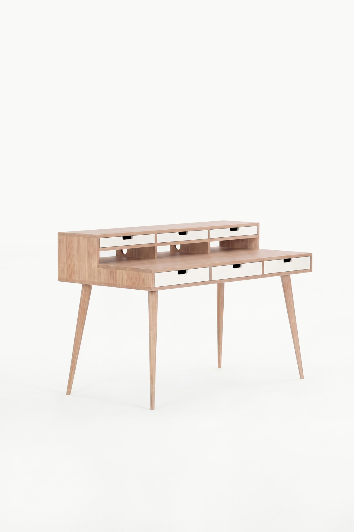 Empty HEIM 140 desk in solid oak with six white drawer fronts, angled against a plain white background