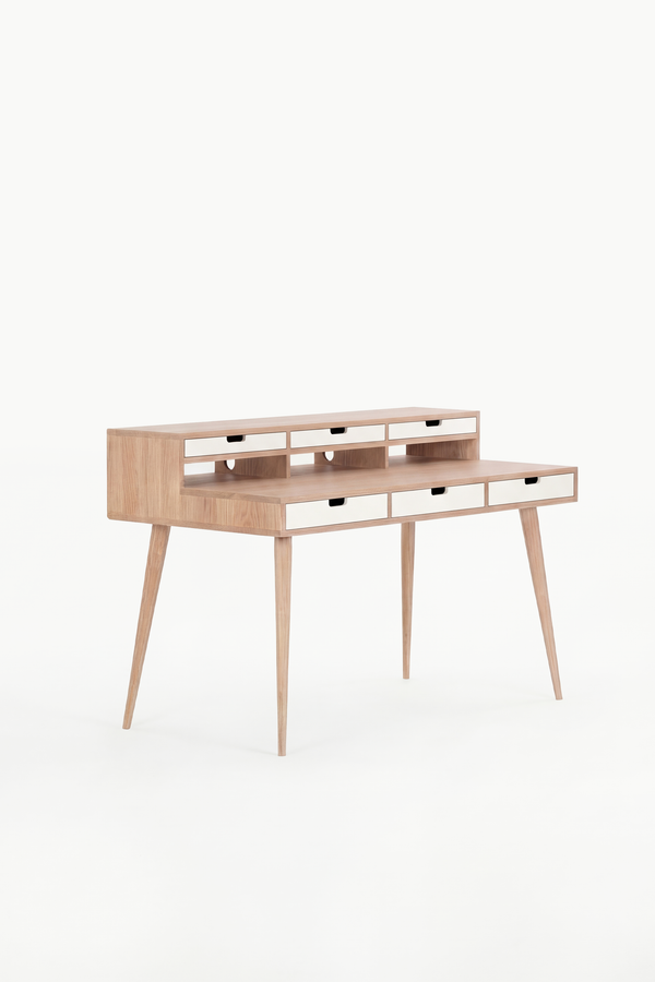Empty HEIM 140 desk in solid oak with six white drawer fronts, angled against a plain white background