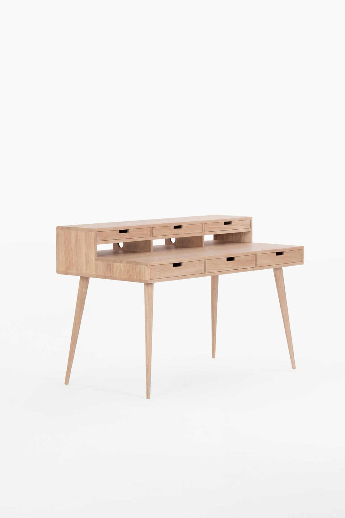 Empty HEIM 140 desk in solid oak, angled to show semicircular openings at the back of the hutch niches