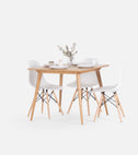 YRKE square dining table in solid oak with four white shell chairs, set with plates and a vase of eucalyptus