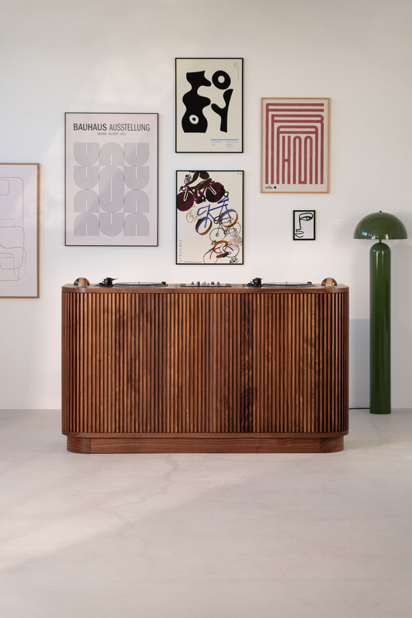 Mid-century modern bar with wood paneling, abstract art on white wall, and a green floor lamp.