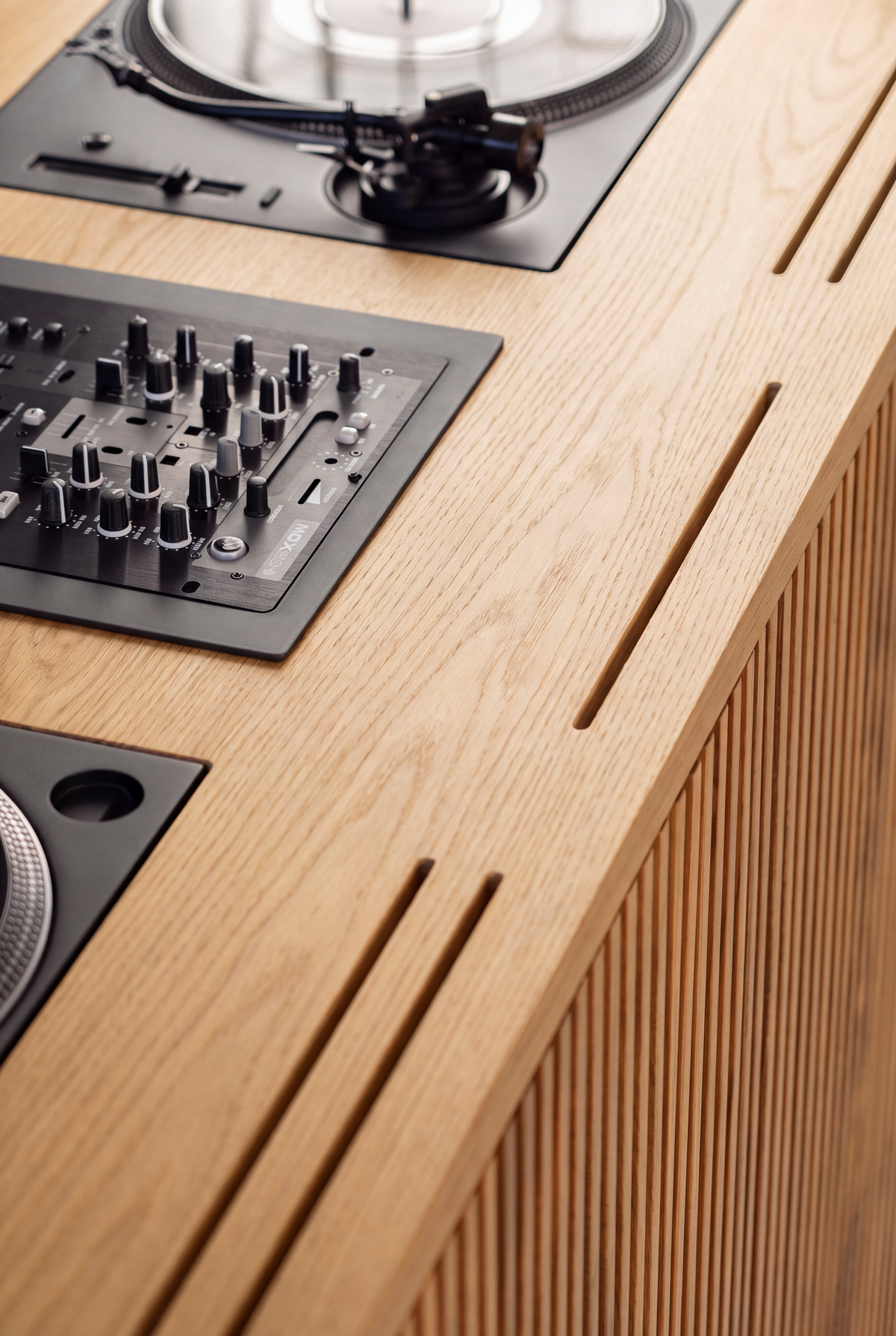 Overhead close-up of LOOP in solid oak, showing a flush-mounted turntable and mixer with slots along the front edge