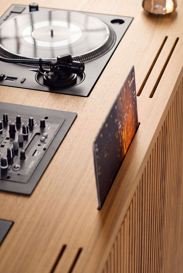 Top-down detail of LOOP in solid oak, with a record sleeve in a slot beside the turntable and mixer