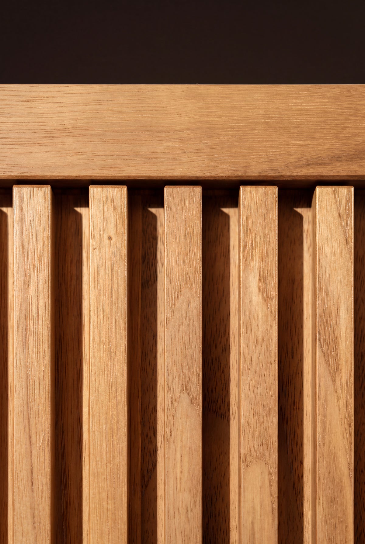 Macro detail of LOOP in solid oak, showing milled vertical grooves below the front rail