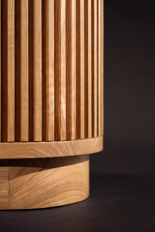 Close-up of LOOP in solid oak, where the rounded, grooved corner sits above a curved recessed plinth