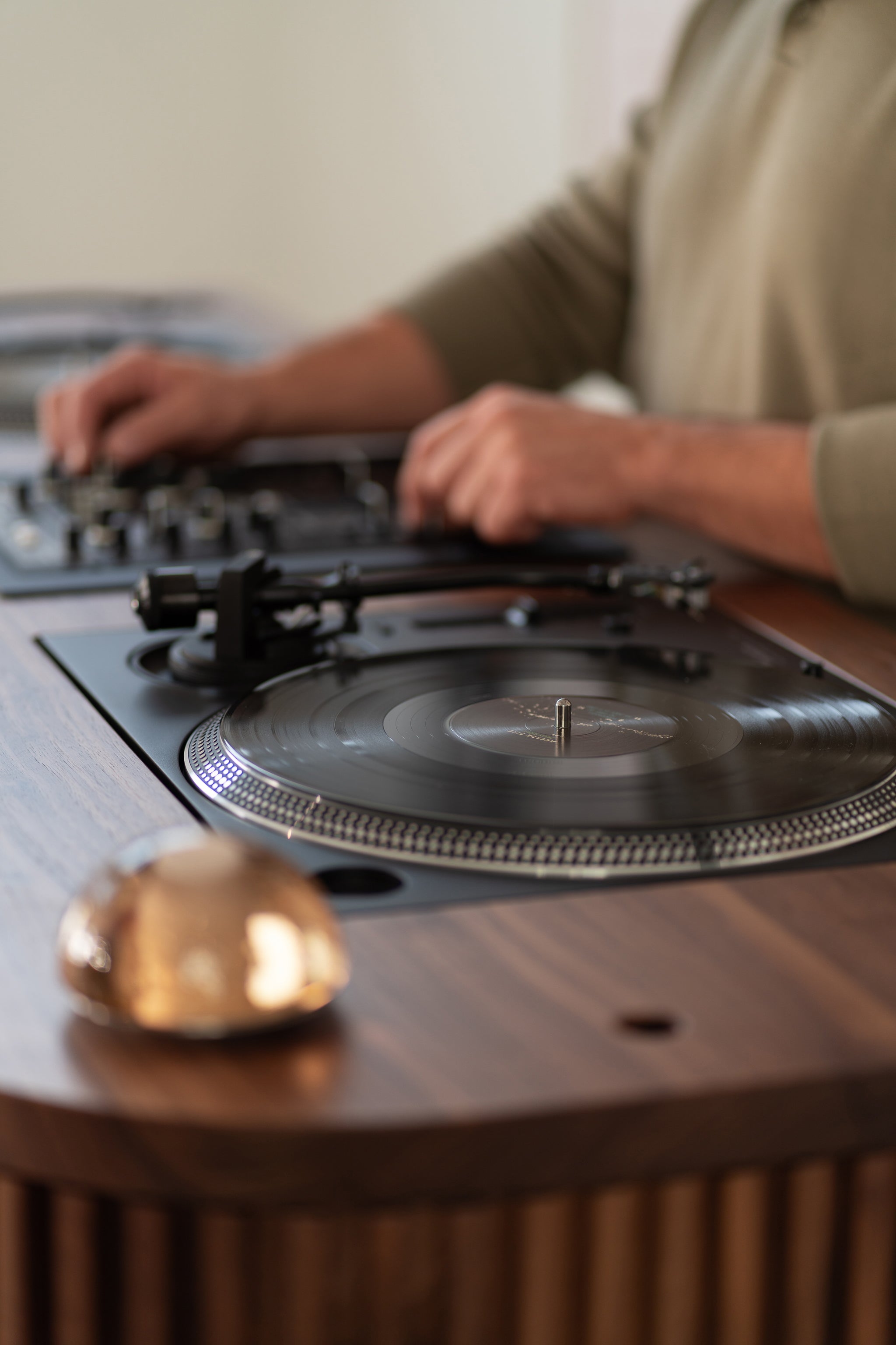 Close-up of a person using a DJ turntable with a vinyl record.
