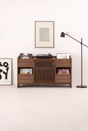 FUSE X hi-fi cabinet in solid walnut seen from the front in a light room, with a turntable and records on top