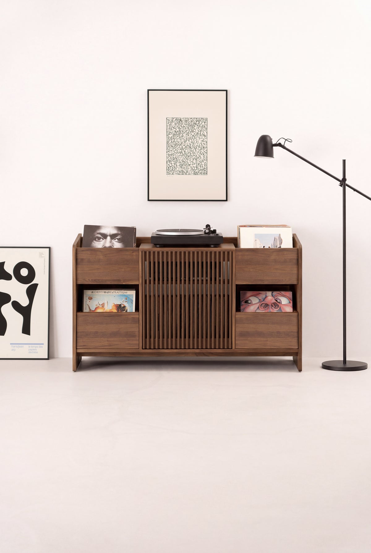 FUSE X hi-fi cabinet in solid walnut seen from the front in a light room, with a turntable and records on top
