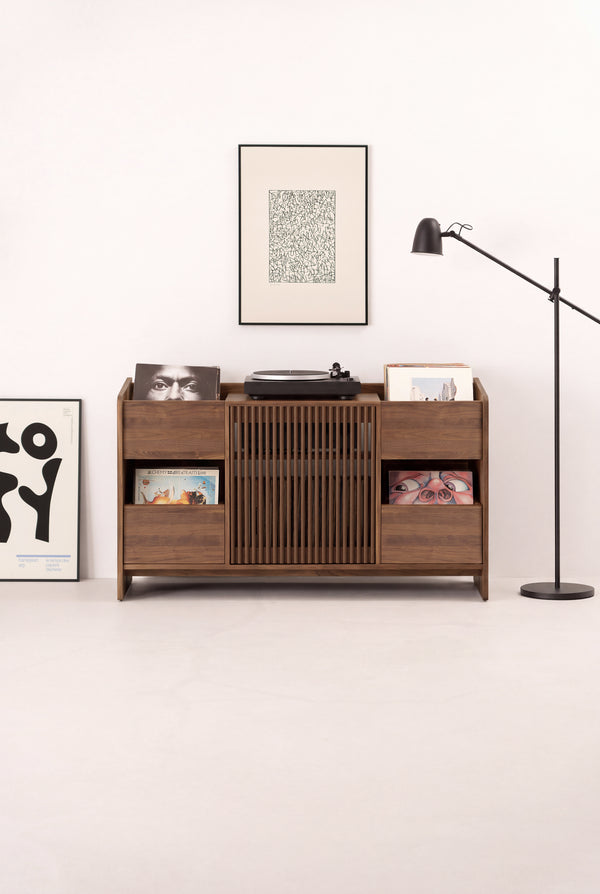 FUSE X hi-fi cabinet in solid walnut seen from the front in a light room, with a turntable and records on top