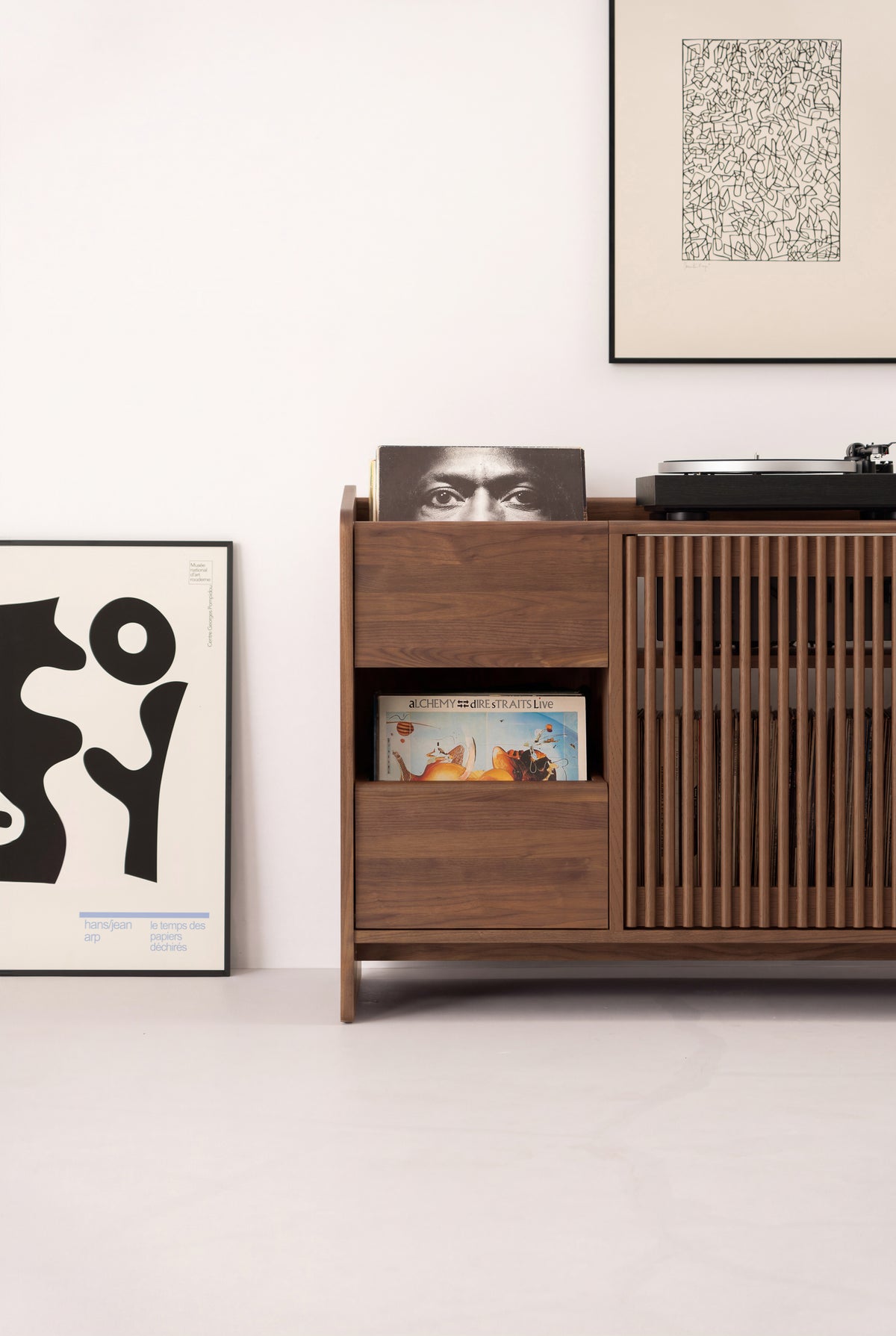 Front view of the left section of the FUSE X in solid walnut, with record niches, a closed drawer and door slats