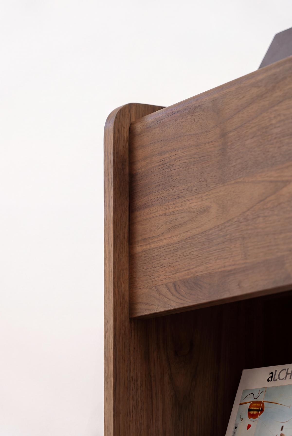 Close-up of the FUSE X in solid walnut showing the rounded side panel edge and wall of the top niche