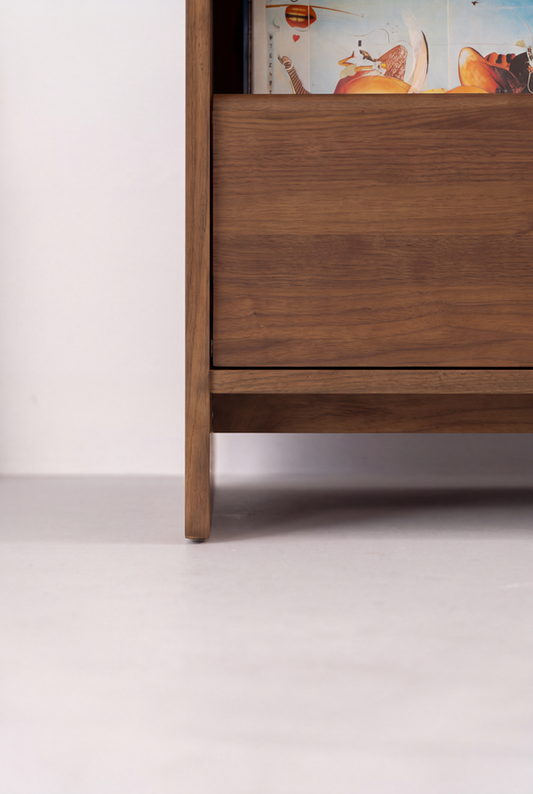 Close-up of the FUSE X in solid walnut showing a closed drawer front, the base rail and side panel