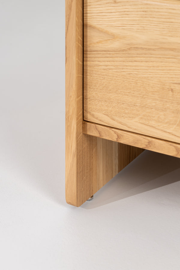 FUSE XX in solid oak, close-up near floor level of the side panel and metal foot beneath the drawer front