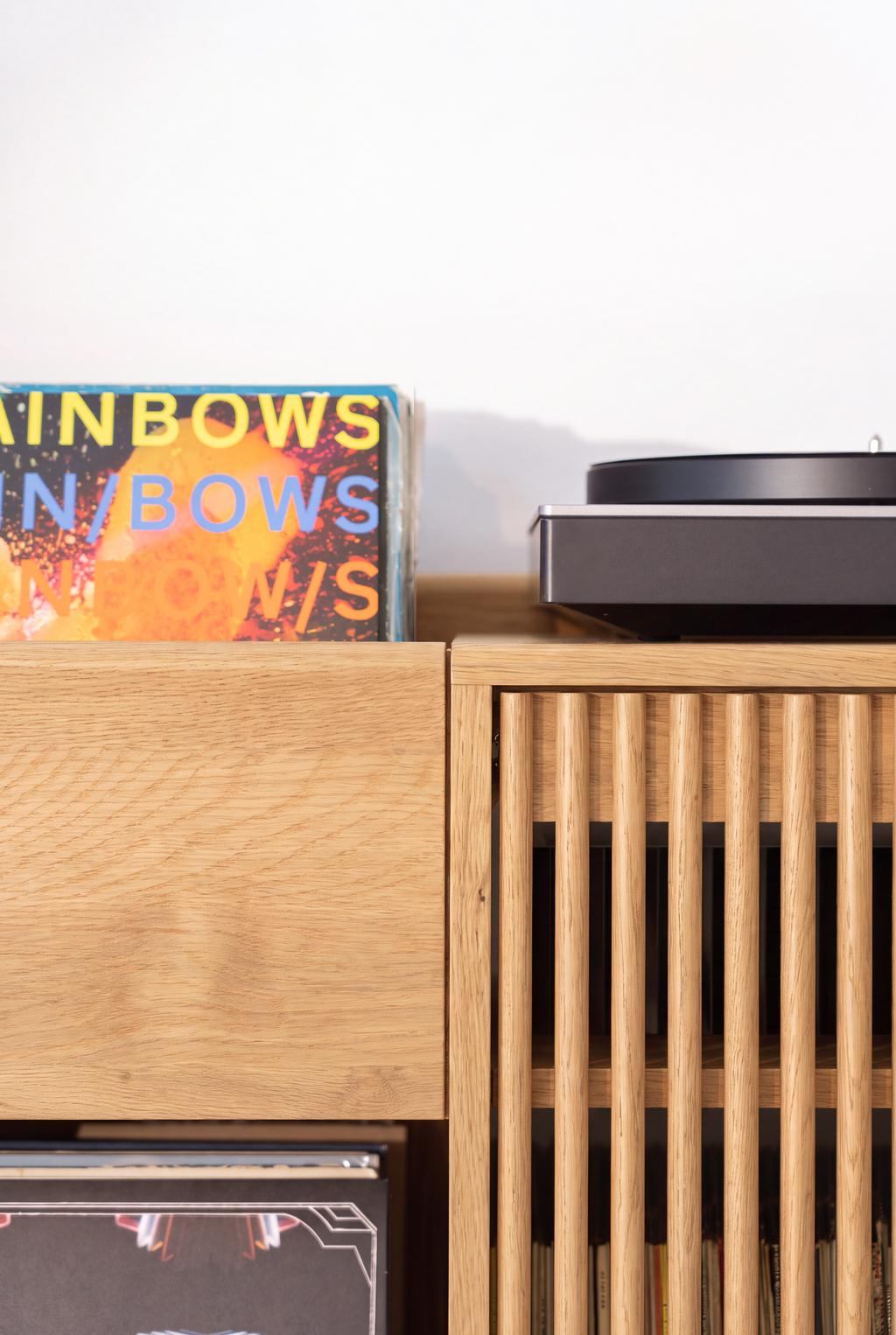 FUSE XX in solid oak, close-up where a drawer front meets rounded door slats, with a record sleeve and turntable above