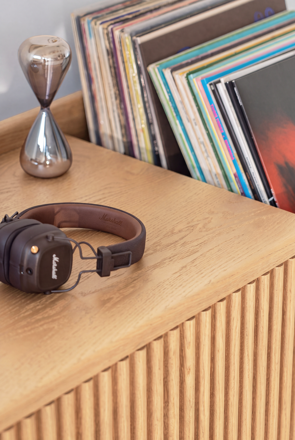 Close-up of the FUSE XX in solid oak, with headphones and an hourglass on top and records in the end niche