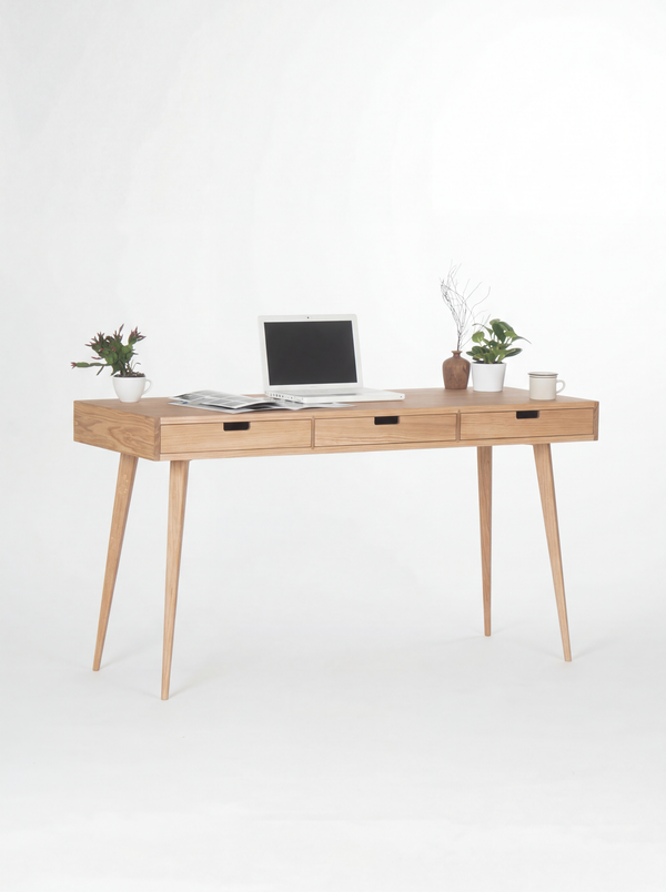 HEIM 140 home office desk in oak wood, angled view with three wooden drawer fronts, a laptop and two plants