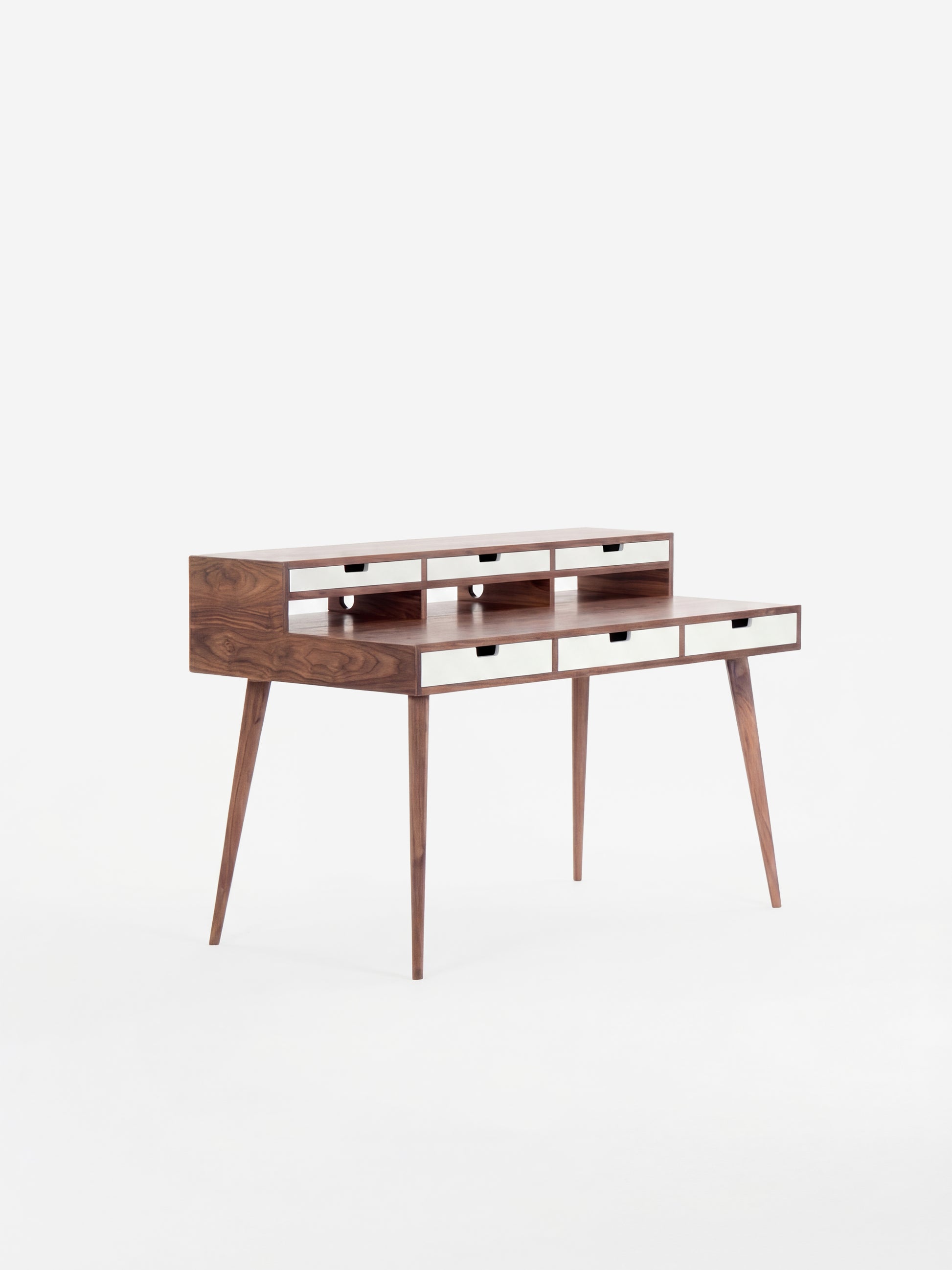 Mid-century modern wooden desk with narrow drawers and tapered legs.