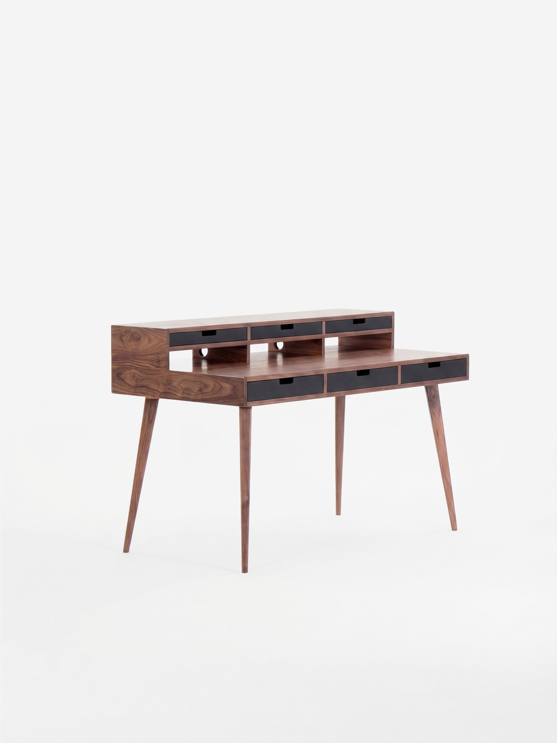 Mid-century modern wooden desk with narrow drawers and tapered legs.