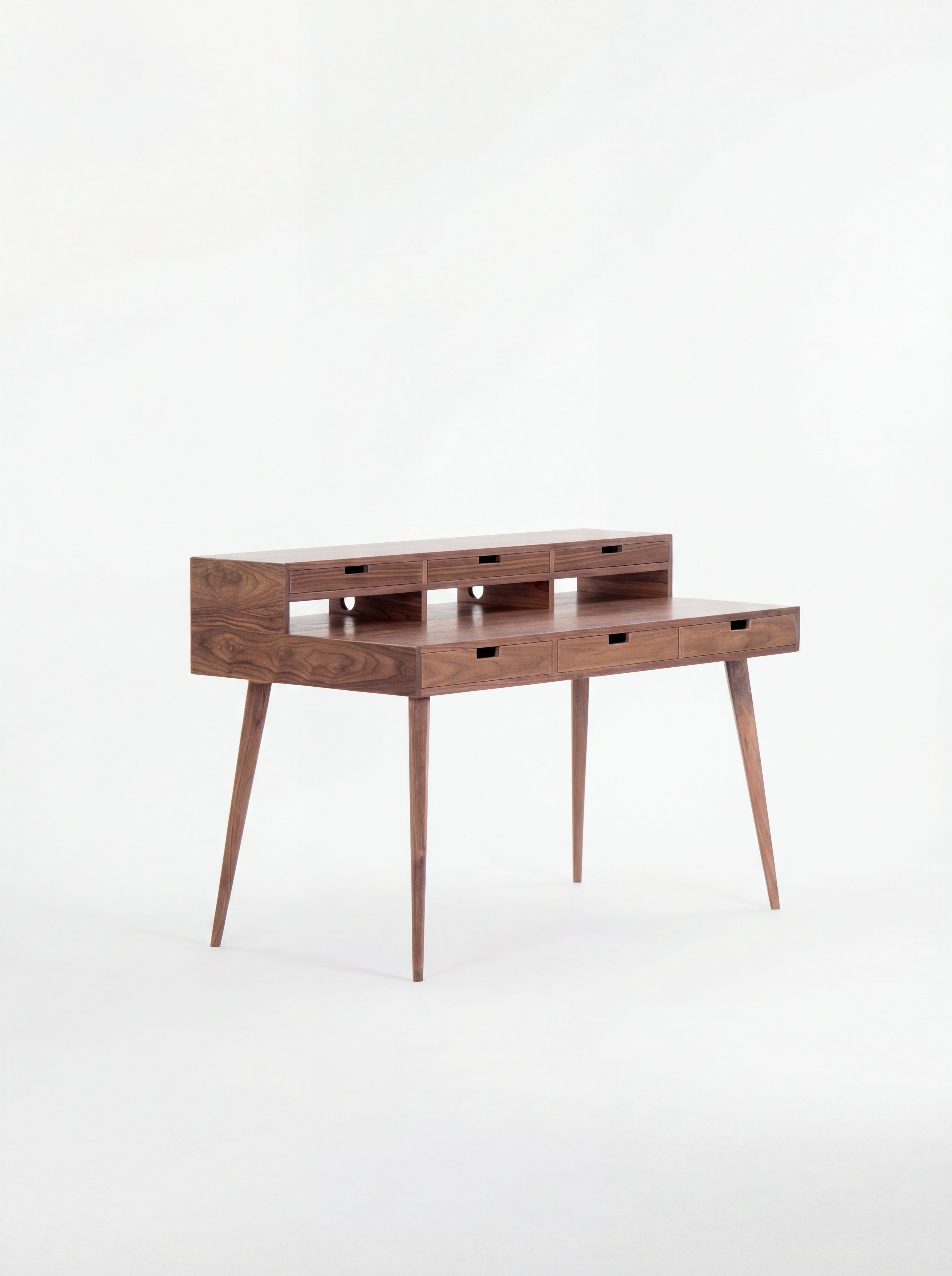 Mid-century modern wooden desk with narrow drawers and tapered legs.