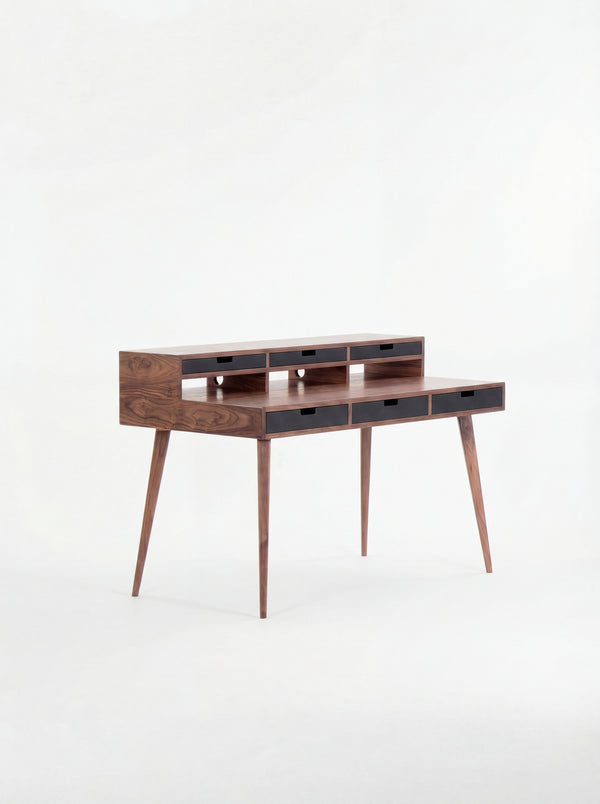 Mid-century modern wooden desk with narrow drawers and tapered legs.