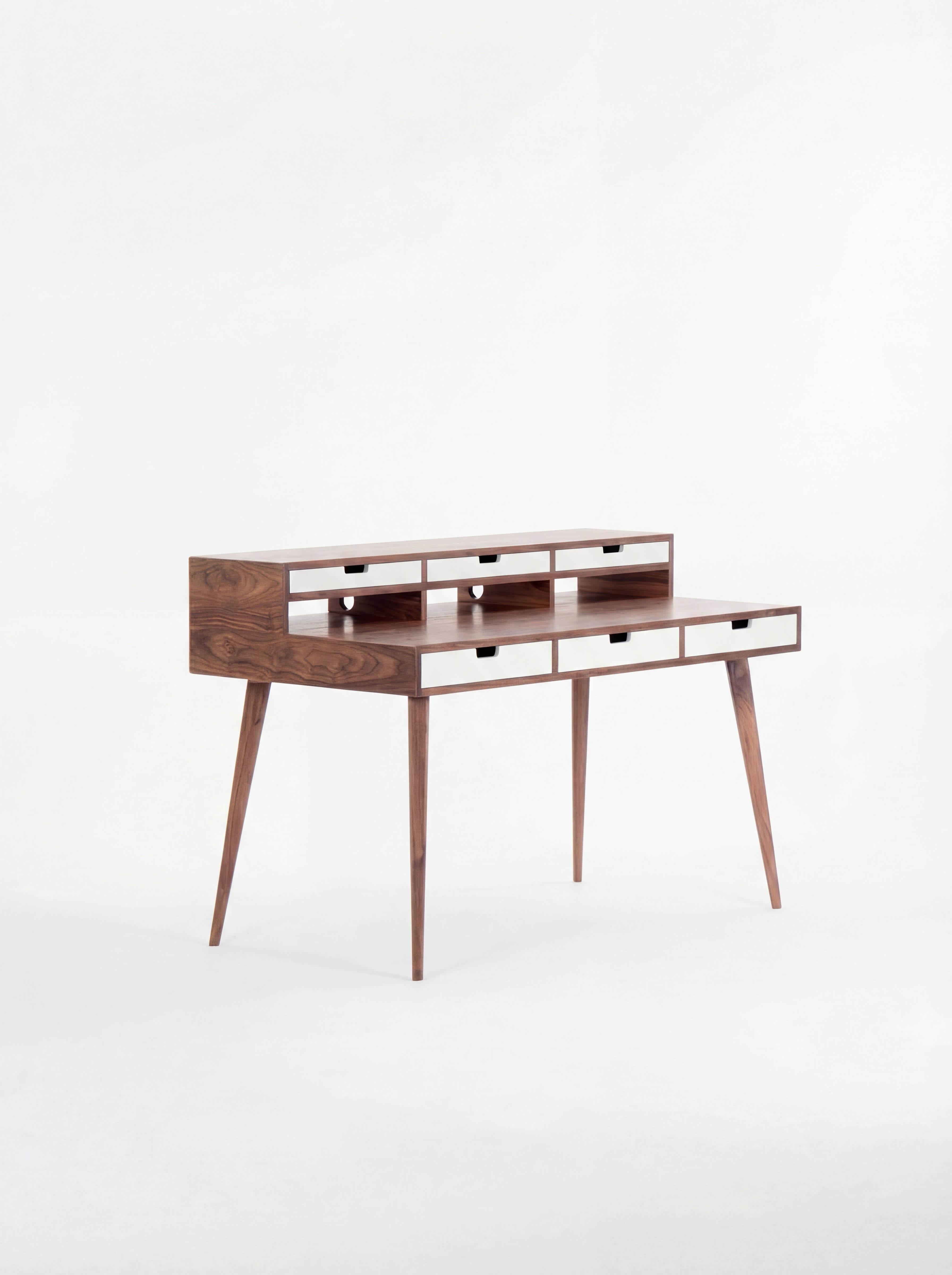 Mid-century modern wooden desk with narrow drawers and tapered legs.