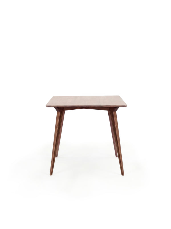  A wooden mid-century modern table with tapered legs against a white background.