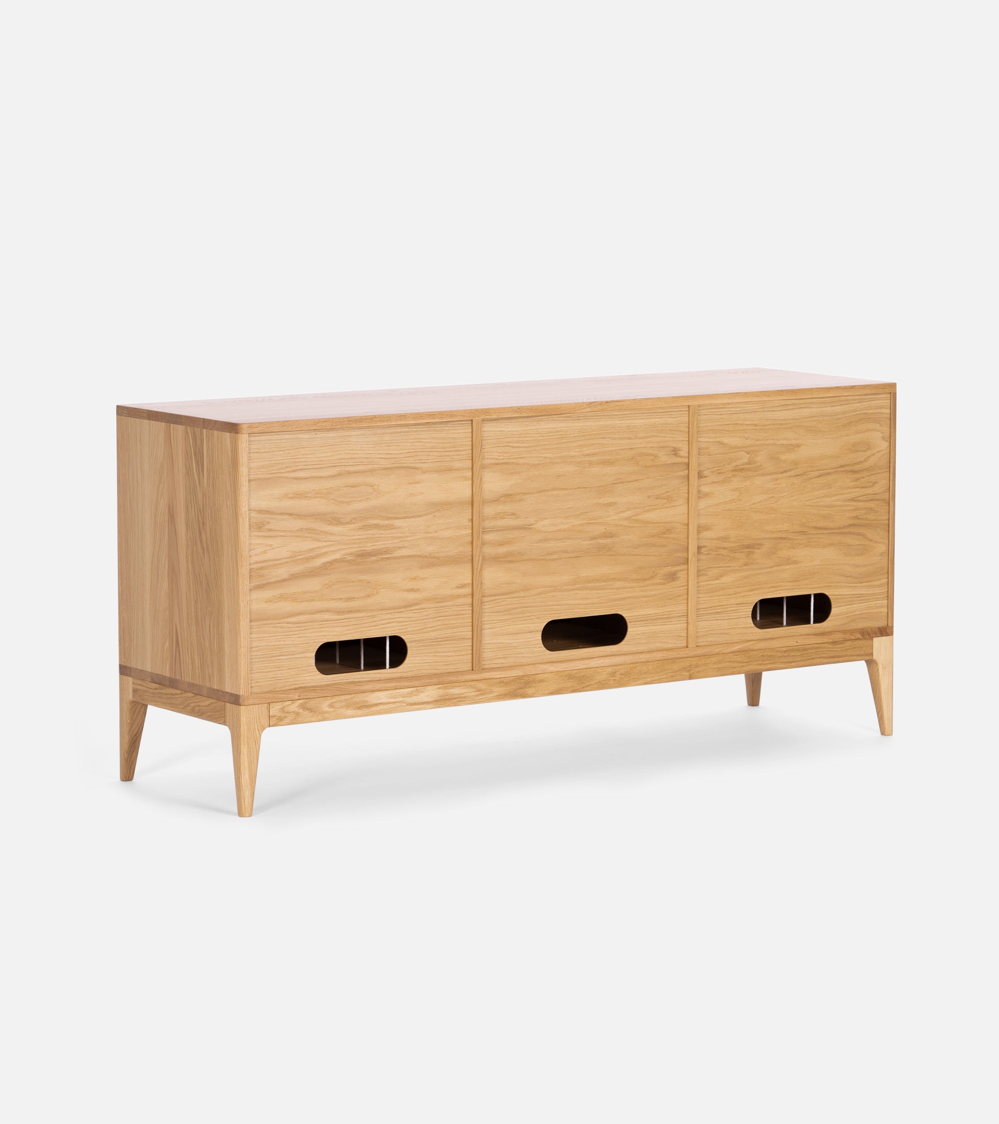 A wooden sideboard with three sliding doors, each featuring an oval cutout handle, on four tapered legs.