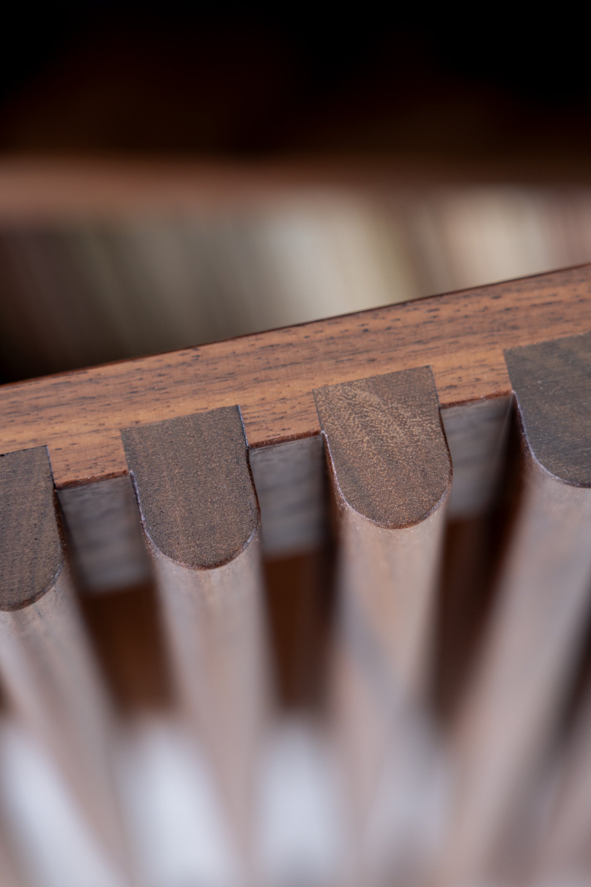 Close-up of the angled wooden slats of a piece of furniture or decoration, displaying smooth finishes and natural grains.