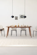 YRKE mid-century dining table in solid American walnut, set for a meal, with four boucle chairs and two black pendant lamps