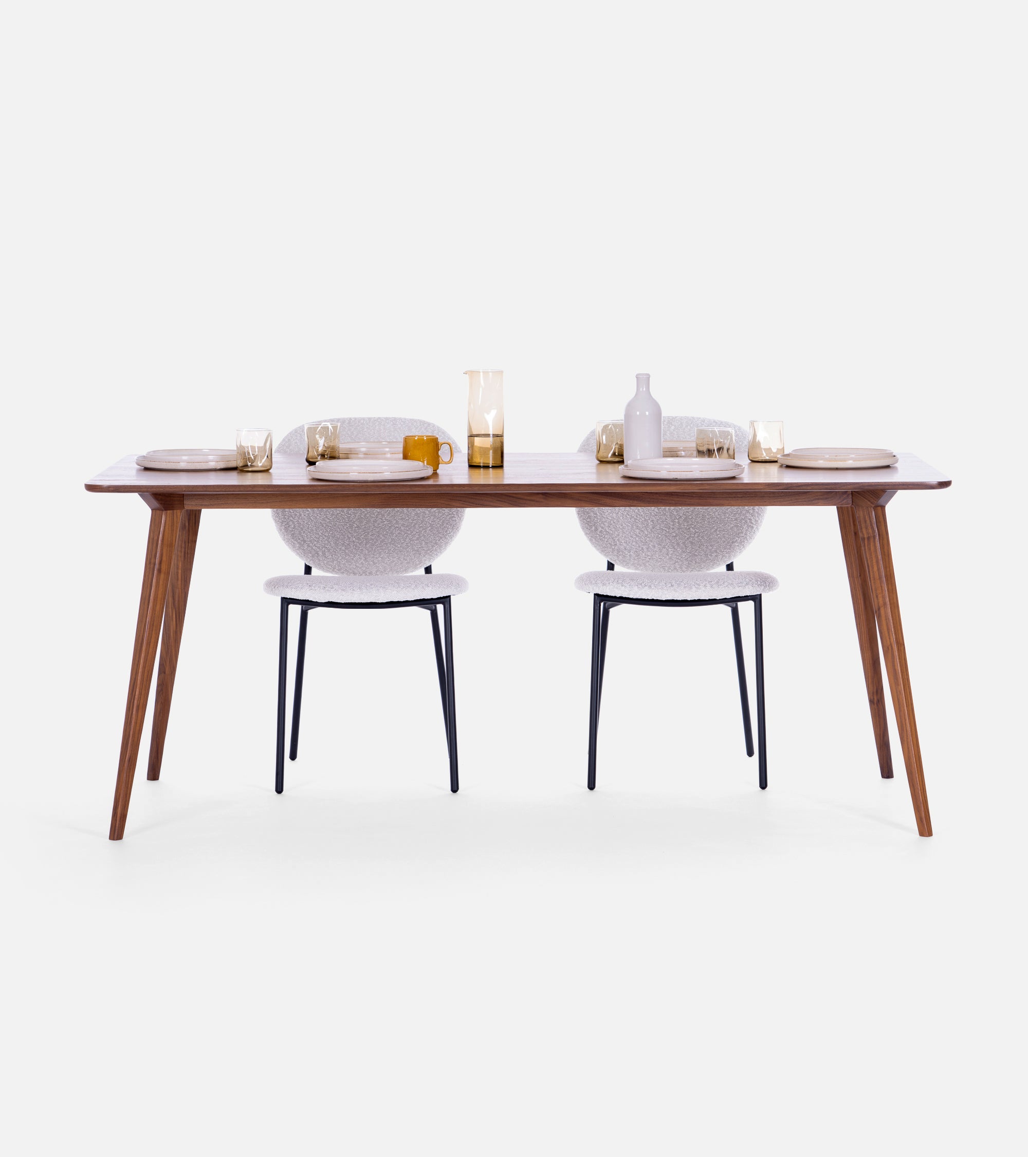 Modern dining table set with two white chairs and minimalist tableware against a plain background.