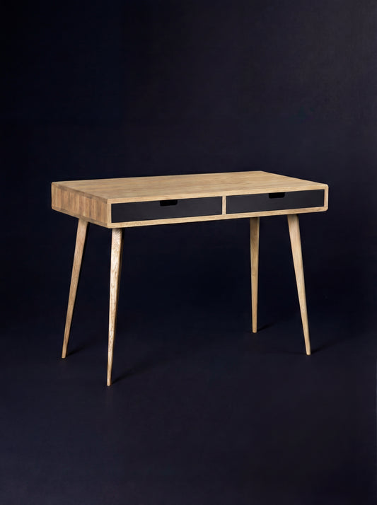 HEIM 105 desk in solid oak, seen at an angle with a bare top and two black drawer fronts on a dark background