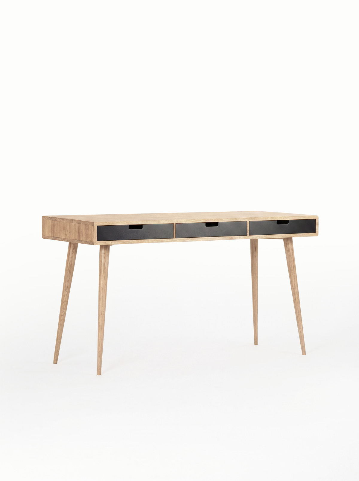 Three black drawer fronts on the empty HEIM 140 desk in solid oak, shown at an angle against a white background