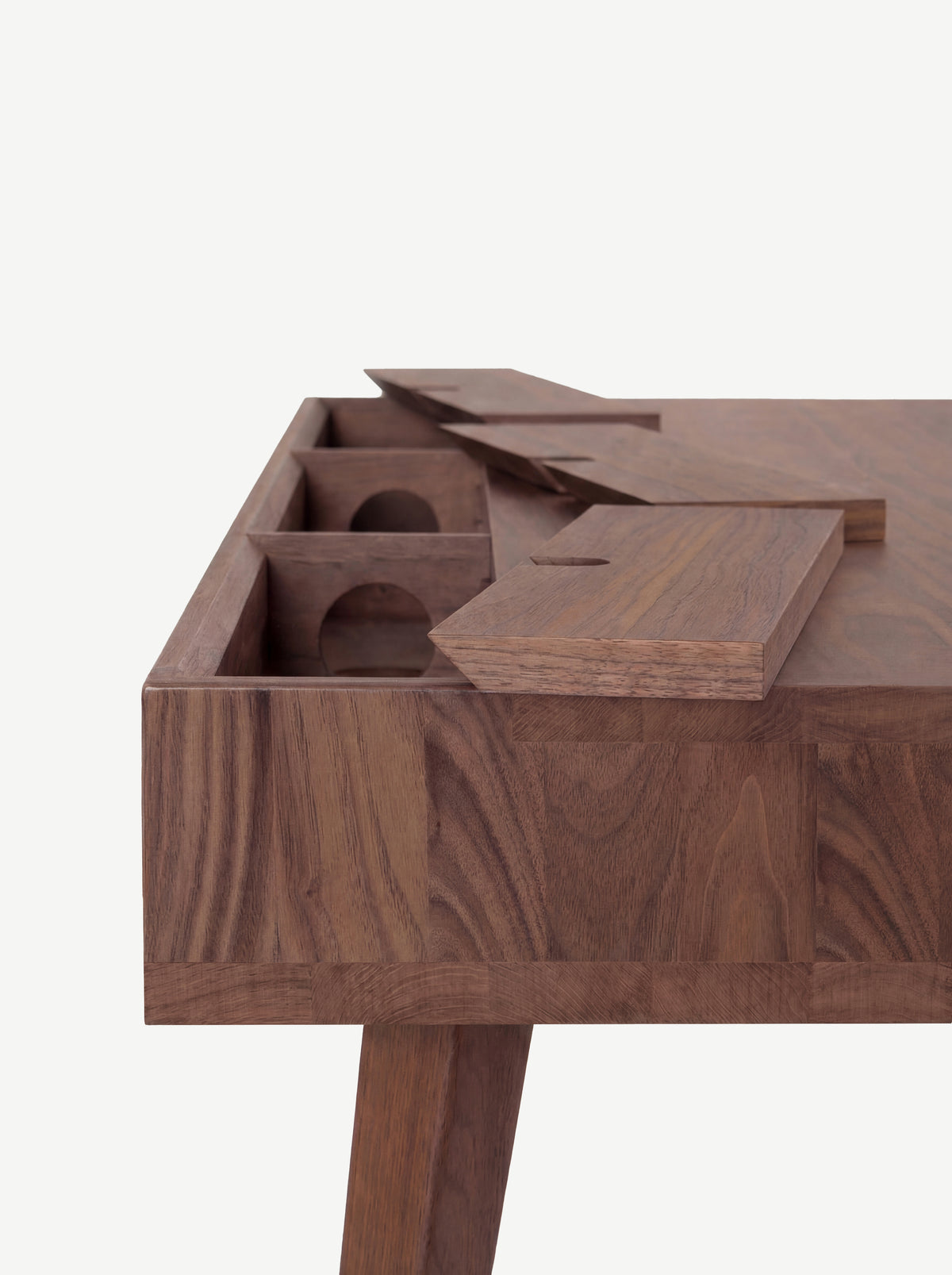 Back corner of the HEIM 140 desk in solid walnut with all cable flaps raised above compartments with round holes