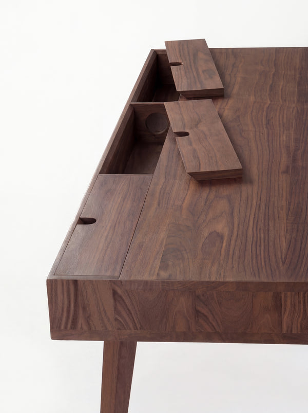 Close-up of two raised cable flaps on the HEIM 140 desk in solid walnut, with joined strips visible at the edge