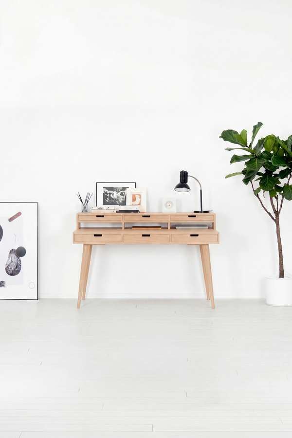 Front view of the HEIM 140 office desk with hutch in solid oak, with a plant and poster in a bright room