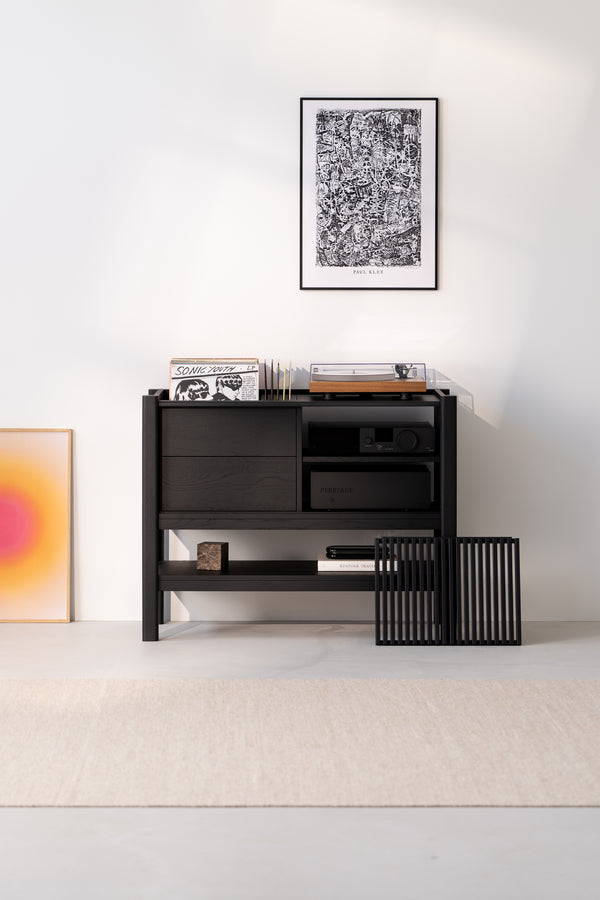 Minimalist room with a black shelf, vinyl records, turntable, and art on the wall.