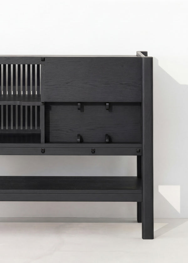 Black wooden sideboard with slatted shelves and closed cabinets against a white wall.