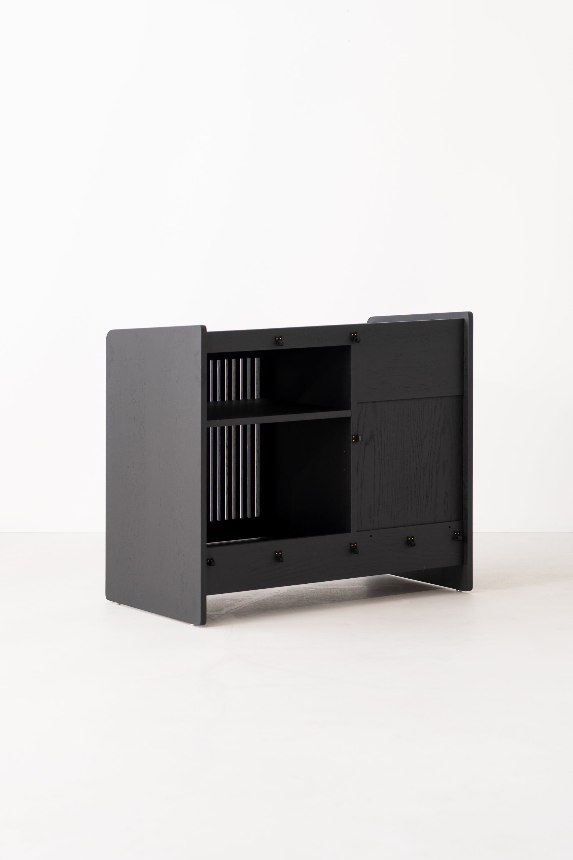 Black modular cabinet with open shelves and slatted sides against a plain white background.