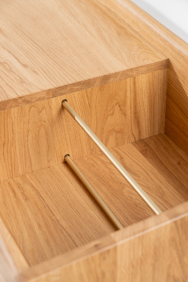 Close-up of an empty niche in the FUSE X in solid oak, with two brass divider rods and visible grain