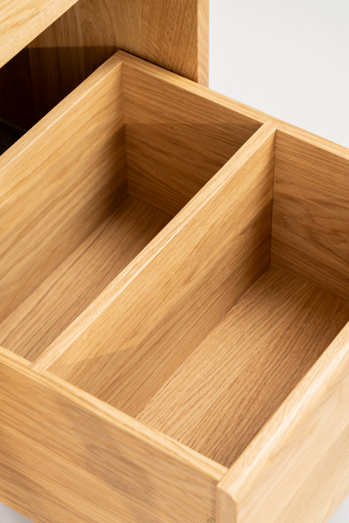 FUSE X in solid oak, close-up of an empty pulled-out drawer with a central divider and oak interior