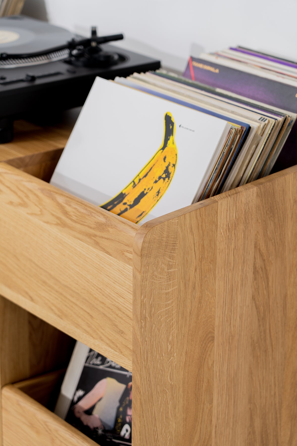 FUSE X in solid oak, close-up of records in a niche with rounded edges and a turntable behind