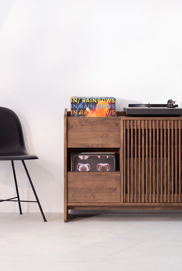 FUSE XX in solid walnut, front view of an end section with a record niche, closed drawer and a chair beside it