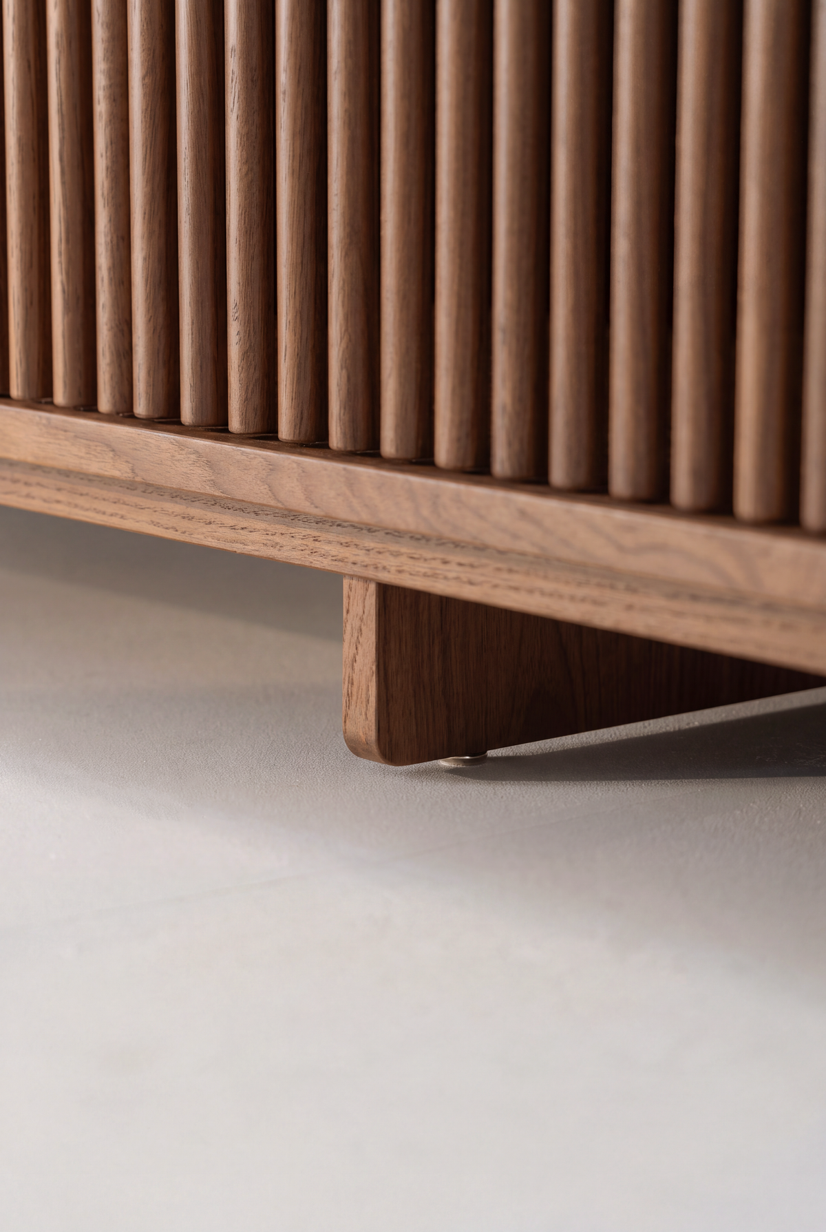 FUSE XX in solid walnut, low-angle detail of the plinth, wooden center support and thin metal brace