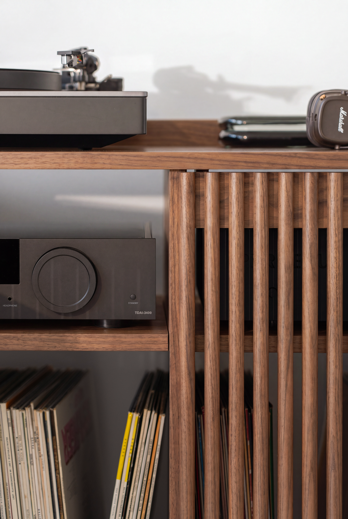 Open center compartment of the FUSE XX in solid walnut, with an amplifier, records below and a turntable above