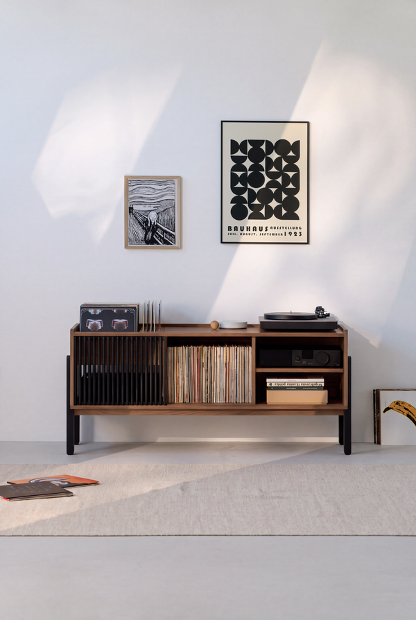 VIBE in solid walnut in a sunlit room, with black slats on the left, records in the center and an amplifier on the right